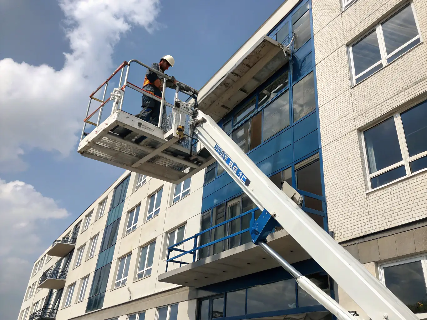 A mobile elevating work platform (MEWP) being used to access a building facade, demonstrating a traditional method of height access alongside modern techniques.