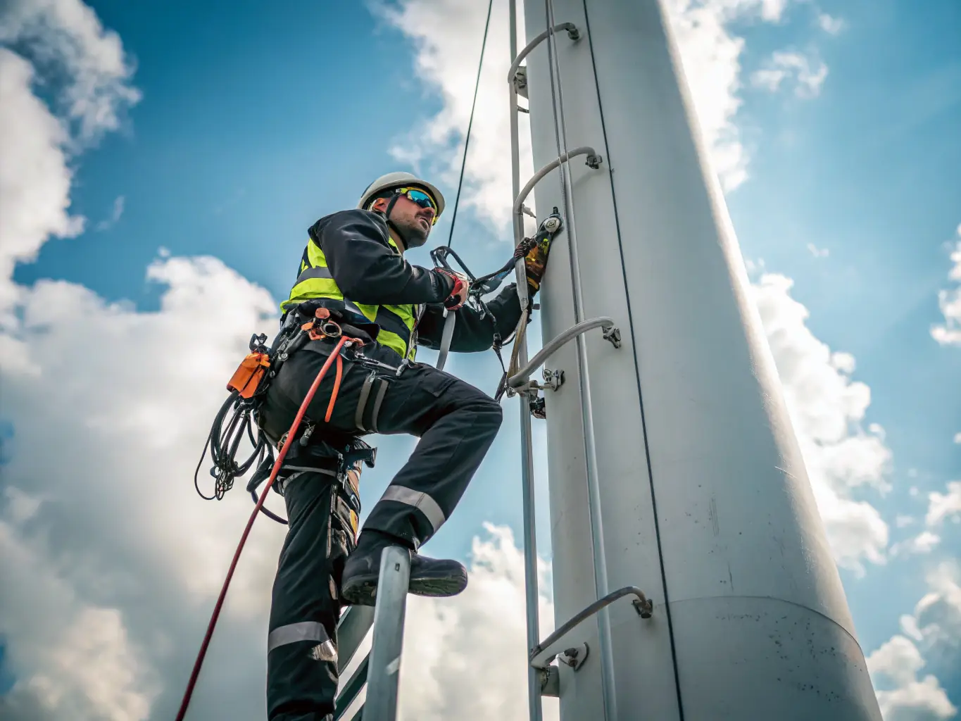 A photograph of technicians installing a horizontal lifeline system on a rooftop, with safety harnesses and lanyards visible, emphasizing the precision and care taken during the installation process.